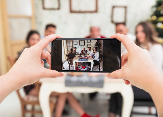 Person taking picture of family at festive table Free Photo