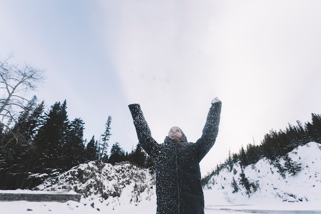 Person throwing snow on forest background Free Photo