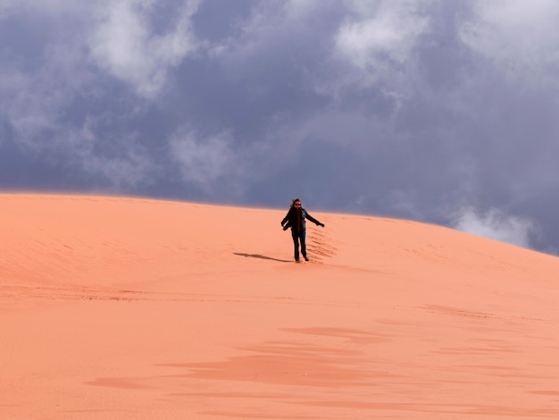 アメリカ ユタ州 コーラルピンクサンドデューン州立公園の砂漠を歩く人 プレミアム写真