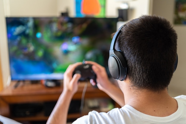 Premium Photo | Person wearing headphones and playing video games on tv