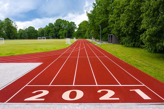 Perspective view of an open - air stadium with red running tracks, with number 2021, new year celebration concept Premium Photo