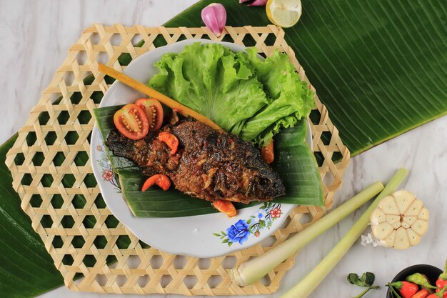 Premium Photo | Pesmol fish using goldfish. add fried fish to the pan ...