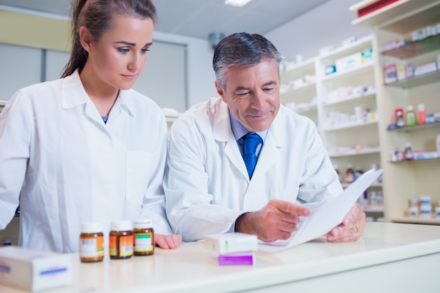 Premium Photo | Pharmacist showing a prescription to his trainee