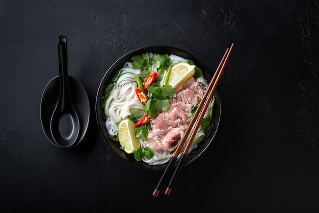 Premium Photo | Pho bo vietnamese soup with beef and rice noodles on a ...