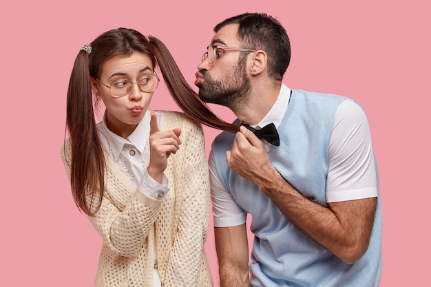 2つのポニーの尾を持つ女性のオタクの写真は 大きな眼鏡をかけ クラスメートからのキスを受け取ることを拒否します 無料の写真