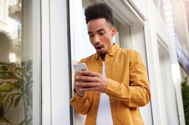 Free Photo | Photo of young amazed dark skinned guy in yellow shirt ...