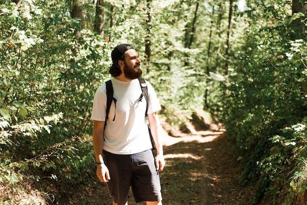 Premium Photo | Photo of young bearded man hiking in forest during ...