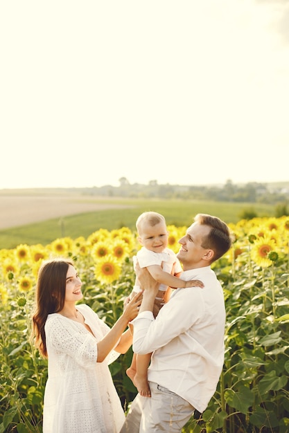 Free Photo | Photo of a young family at the sunflowers field on a sunny