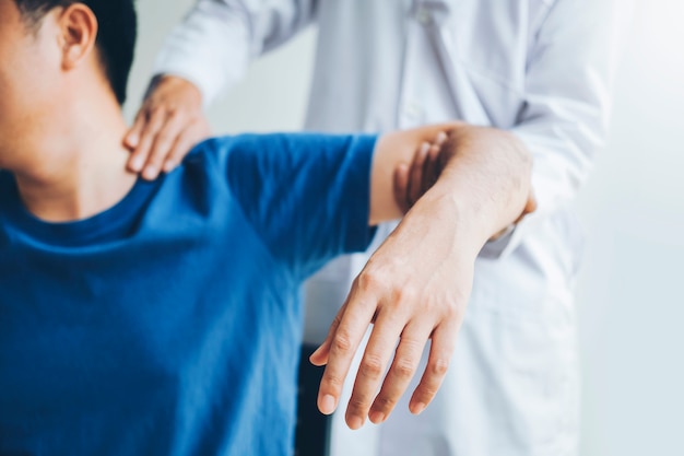 Physical doctor consulting with patient about shoulder muscule pain problems physical Premium Photo