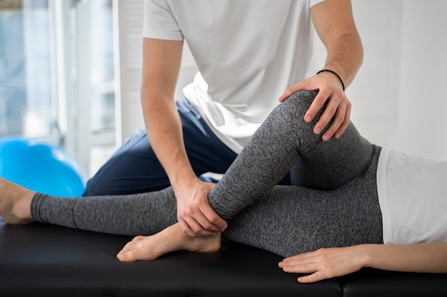 Free Photo | Physiotherapist helping patient's leg close up