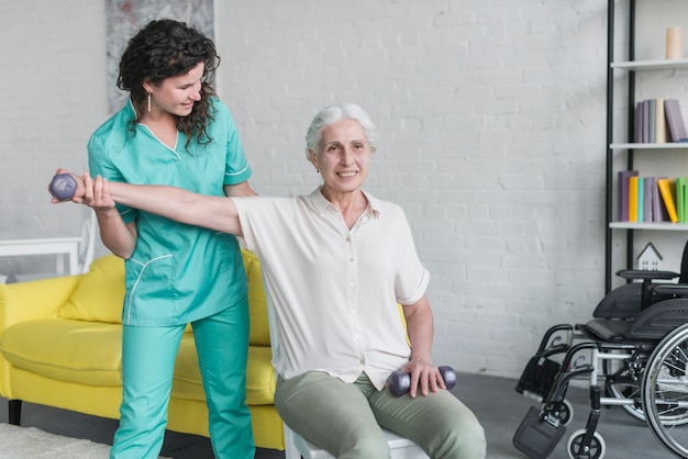 Physiotherapist working with elderly patient in modern clinic Free Photo