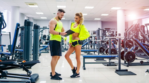 Premium Photo Picture Of Personal Fitness Trainer And Female Client In Gym Posing In Front Of The Camera