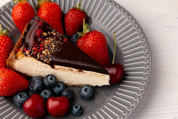 Premium Photo Piece Of Cheesecake With Chocolate Top And Berries