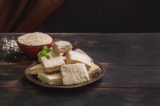 Premium Photo | Pieces of tahini halva, sesame seeds in a bowl, an ...