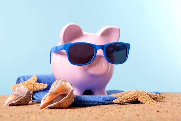 Free Photo | Piggy bank on a beach with sunglasses