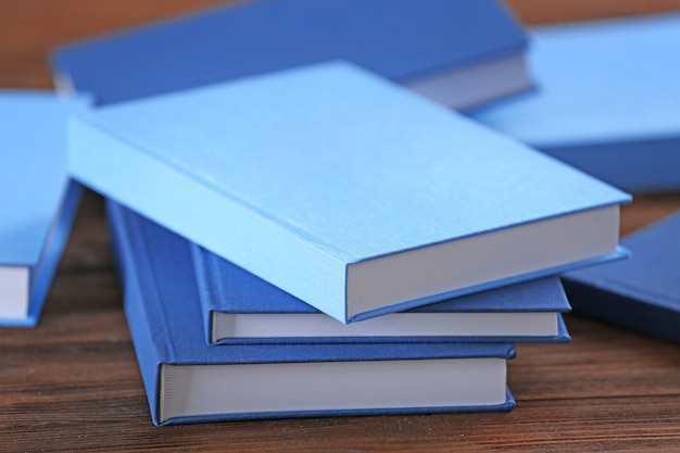 Premium Photo | Pile of blue books on wooden table