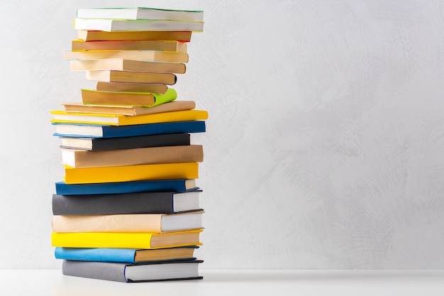 Pile of paperback books on a table | Premium Photo