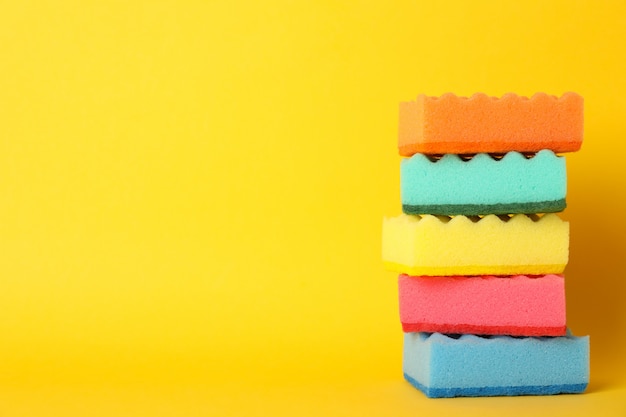 Premium Photo | Pile of sponges for washing dishes on yellow background ...