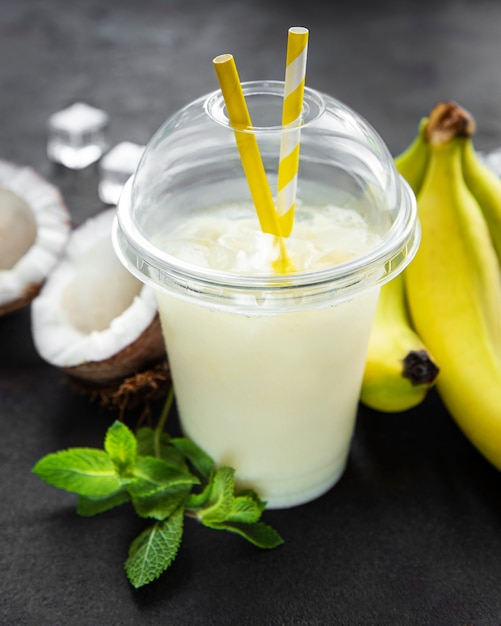 Pina colada alcoholic fresh cocktail served cold with coconut and banana on a black  surface Premium Photo