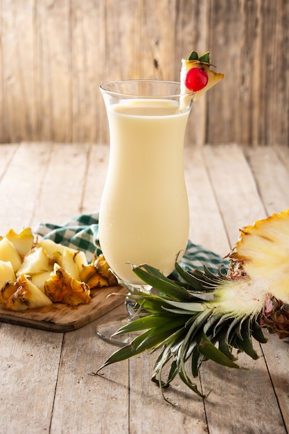 Premium Photo | Pina colada cocktail in glass on wooden table