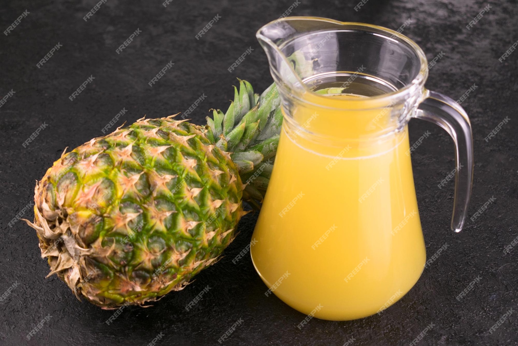 premium-photo-pineapple-and-jug-with-pineapple-juice-on-a-black