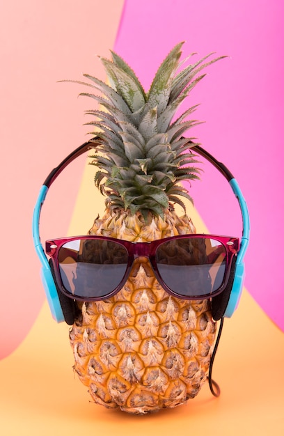 Premium Photo | Pineapple with sunglasses and headphone on orange ...