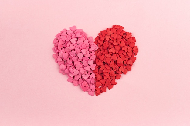 パステルカラーの背景にピンクと赤のバレンタインデーのハート型キャンディー フラットレイ トップビューのハートのテクスチャ 愛の概念 Sainteバレンタイン 母の日のグリーティングカード 招待状 プレミアム写真