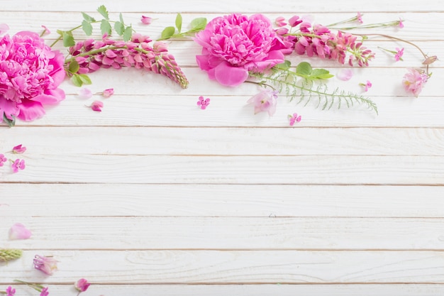 Premium Photo | Pink beautiful flowers on white wooden background