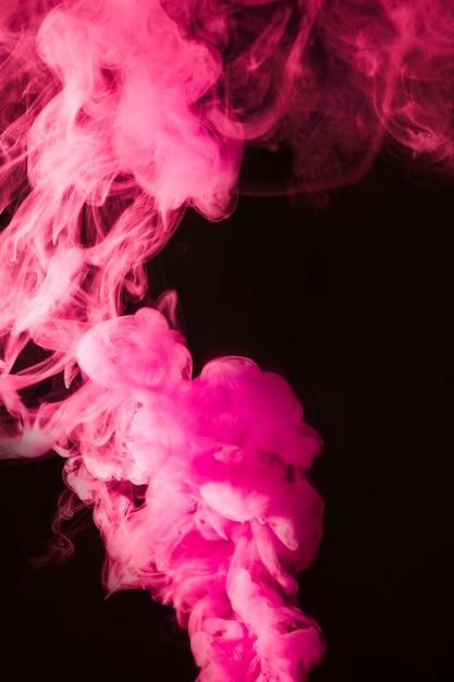 黒の背景にピンクの濃い煙 無料の写真