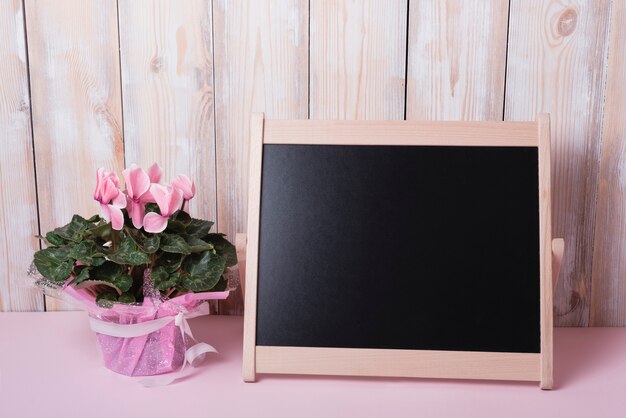 Pink Flower Bouquet With Small Blank Chalkboard On Desk Against