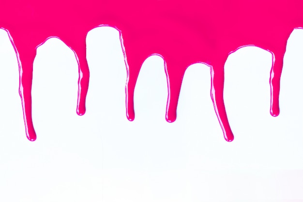 Premium Photo | Pink paint dripping on a white.