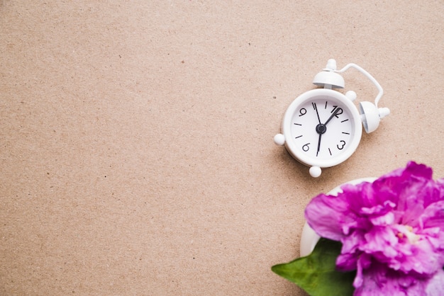 Pink Peony Flower In Vase With White Alarm Clock On Paper Texture