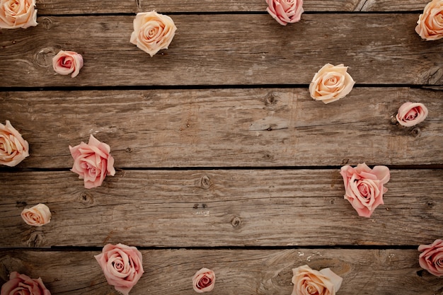 茶色の木製の背景にピンクのバラ 無料の写真