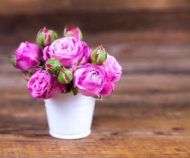 Premium Photo Pink Roses In A Vase On Wooden Surface 6352