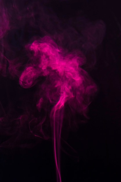 Free Photo | Pink smoke moving upward over the black background