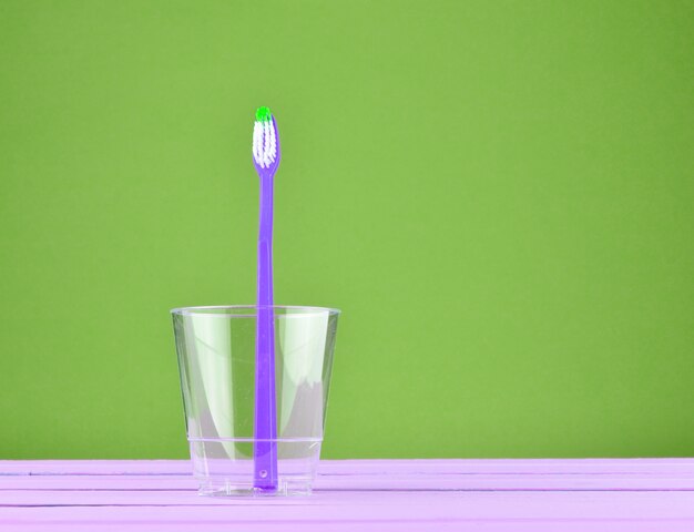 Premium Photo Pink Toothbrush In A Transparent Cup On A Minty Green