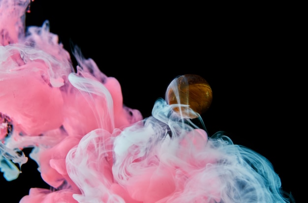 Premium Photo Pink And White Acrylic Inks In Water On A Black Background Surround The Glass Ball Abstract Background