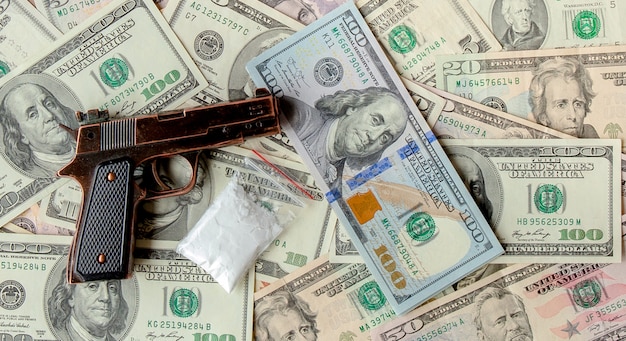 Premium Photo | Pistols and drugs against bunch of dollars