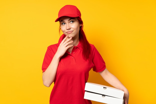 Premium Photo Pizza Delivery Woman Holding A Pizza Over Isolated Wall Scheming Something