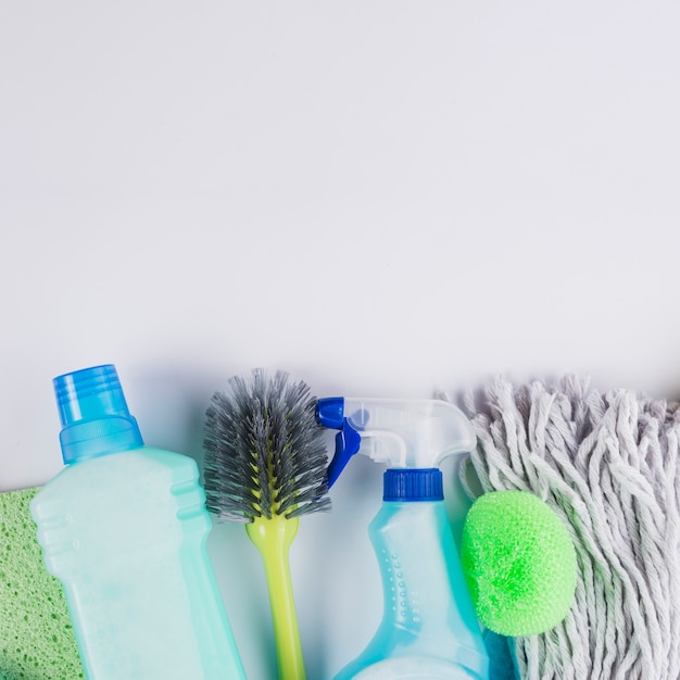 Plastic bottles brush, mop head and sponge on grey background Free Photo