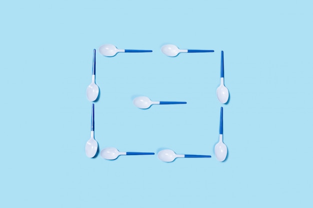 Premium Photo | Plastic spoons on blue background