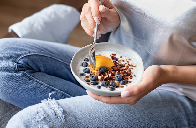 Plate with granola and fresh berries in the hands of a young girl Premium Photo