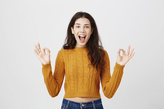 free-photo-pleased-girl-showing-okay-gesture-making-compliment