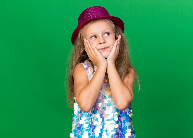 Free Photo | Pleased little blonde girl with purple party hat puts ...