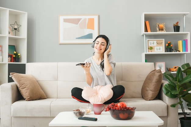 Premium Photo | Pleased young girl with pillow wearing headphones ...