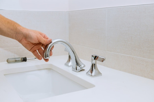 Premium Photo Plumber Fixing Installation Faucet Of A Sink At Work In Bathroom - How To Remove A Bathroom Drop In Sink