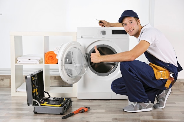  Plumber repairing washing machine Premium Photo