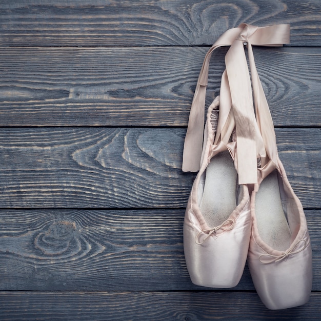 Premium Photo Pointe Shoes Ballet Dance Shoes With A Bow Of Ribbons Hang On A Nail On A Wooden 