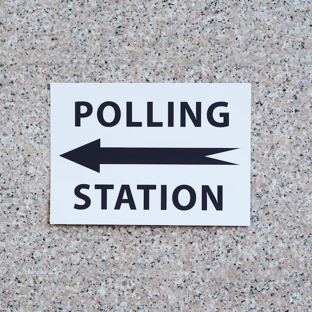 Polling station sign with direction on wall close-up Photo | Free Download