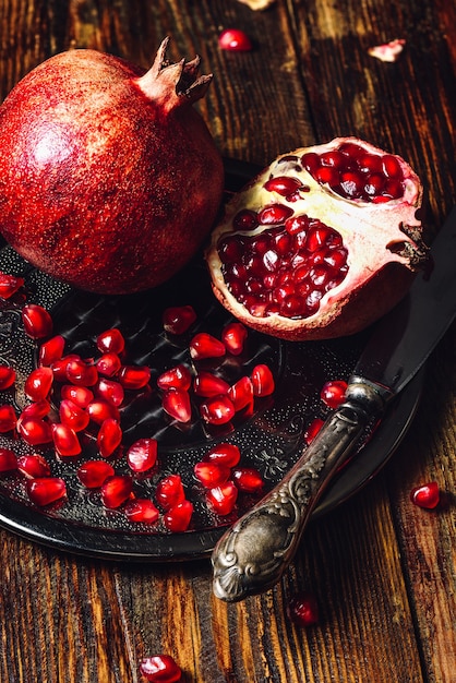 Premium Photo | Pomegranates with seeds and knife.